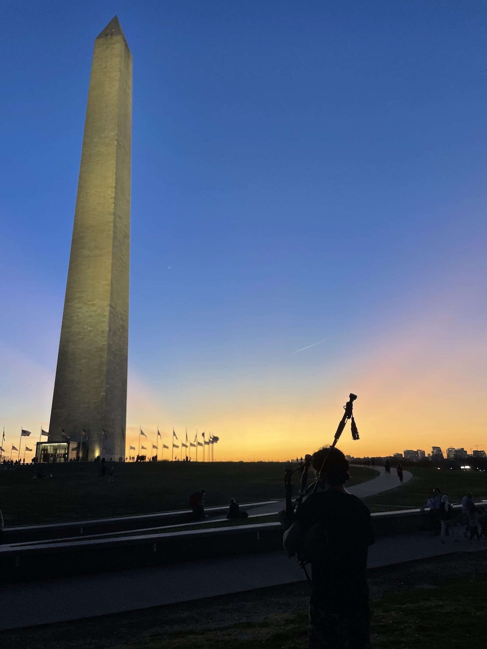 Busking with bagpipes by the Washington Monument at sunset, 2023