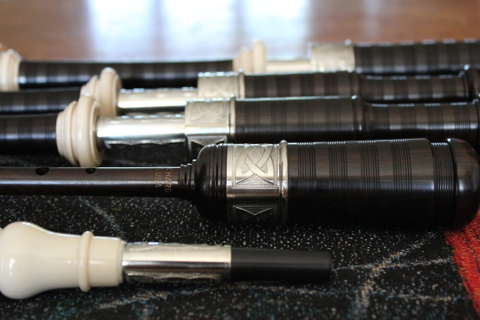 Great Highland Bagpipe drones, chanter, and blowpipe laid out on tartan